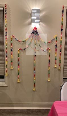 the wall is decorated with colorful beads and tassels on it's sides