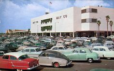 many old cars are parked in front of a building with palm trees on the roof