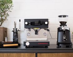 a coffee machine sitting on top of a counter next to a potted plant and other items