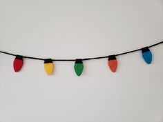 christmas lights are hanging on a string with black cords and red, green, yellow, and blue lights