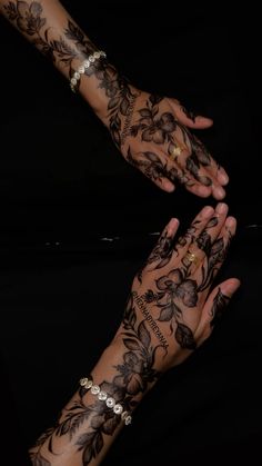 two hands that have tattoos on them