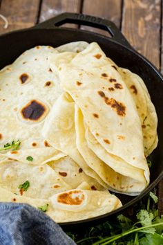 tortillas in a skillet with parsley on the side, ready to be eaten