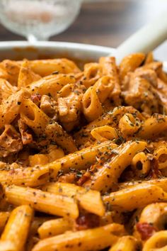 a bowl filled with pasta and sauce on top of a table