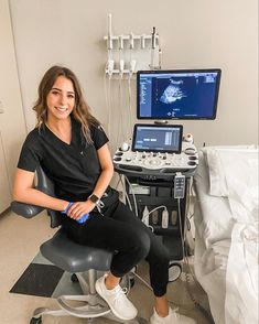 a woman sitting on a chair in front of a laptop computer and medical equipment,