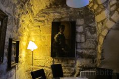 an old stone room with paintings on the wall and a table in front of it