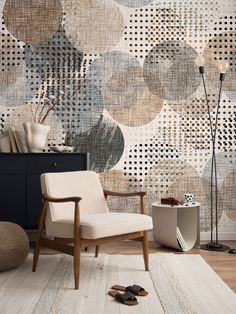 a living room with a chair, rug and wall hangings on the walls that have circles printed on them