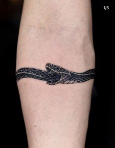 a tattoo on the leg of a person with a snake wrapped around it's arm