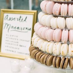 there are many different types of macaroons on the table, but one is pink and white