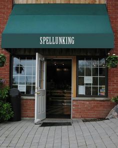 the front entrance to suffolk sperm bank on a brick building with green awning