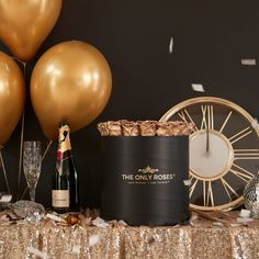 a table topped with champagne and balloons next to a bottle of wine on top of a table