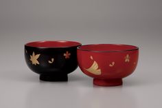 two black and red bowls sitting next to each other