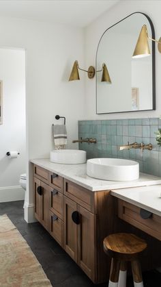 a bathroom with two sinks and mirrors on the wall