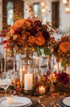 a centerpiece with candles and flowers on top of a table in front of other place settings