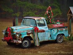 an old pickup truck with a christmas tree in the back