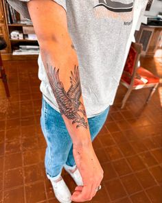 a man with a bird tattoo on his arm