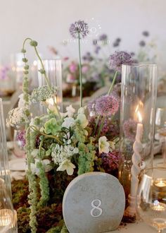 the table is set with flowers and candles