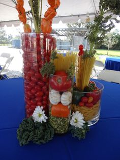 there are many different types of vegetables in the vases on the blue table cloth