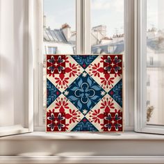 a window sill with a blue, red and white tile design on it