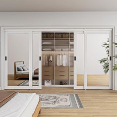 a bedroom with white walls and wooden flooring has an open closet door to the other side