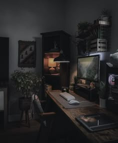 a desk with a computer monitor and keyboard on it in front of a television set