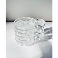 a stack of clear glass cups sitting on top of a white countertop next to each other