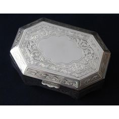 an ornate silver box on a black background