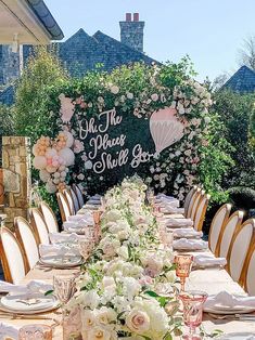 a long table is set with white and pink flowers