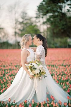 two brides standing in a field of tulips