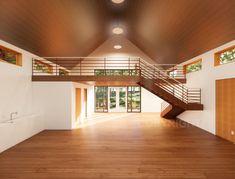 an empty room with wooden floors and stairs