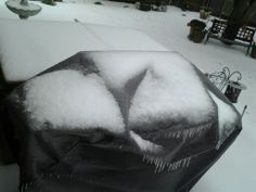 the snow is melting on top of the grill in the back yard, and it's covered with icicles