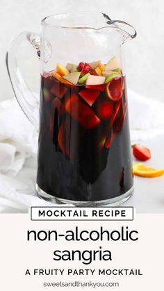 a pitcher filled with liquid sitting on top of a white table next to sliced fruit