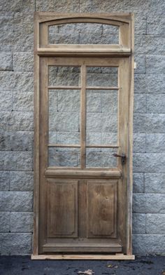 an old wooden door on the side of a stone building with no glass in it