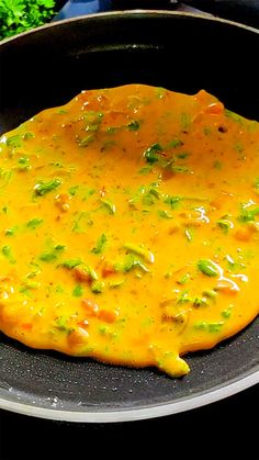 an omelet is being cooked in a frying pan