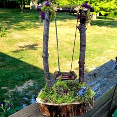 an old tree stump with moss growing on it and hanging from the top, is used as a planter