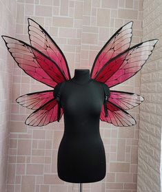 a mannequin wearing a pink and black butterfly wings costume