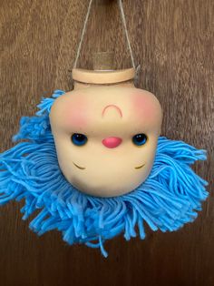 a toy hanging from a string on top of a wooden table next to a wall