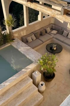 an outdoor living area with couches, table and hot tub in the middle of it