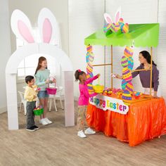 two girls and one boy are playing with an easter decoration