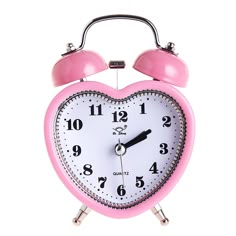 a pink and white heart shaped alarm clock with two bells on each side, against a white background