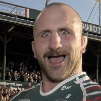 a man with a bald head standing in front of a crowd