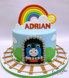 a thomas the train birthday cake with rainbow decoration