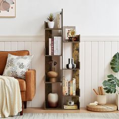 a living room filled with furniture and bookshelves next to a wall mounted plant