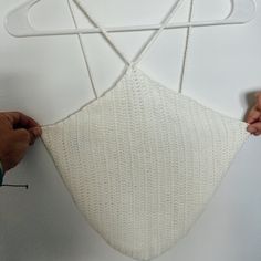 someone is making a piece of art out of knitted material that looks like an inverted triangle