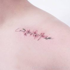 a woman's chest with pink flowers on it and the word love written in cursive writing