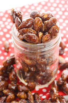 a glass jar filled with raisins on top of a red and white table cloth