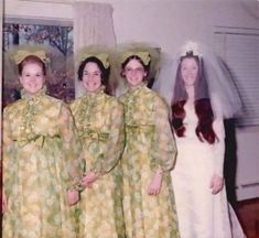 four women in dresses and veils posing for a photo