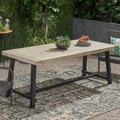 an outdoor table with two chairs and a bowl of succulents on it