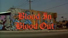 the words blood in blood out are painted on a building