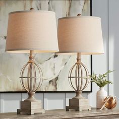 two lamps sitting on top of a wooden table