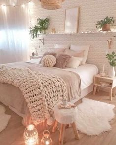 a bedroom with white walls and wooden flooring, lights strung from the ceiling over the bed